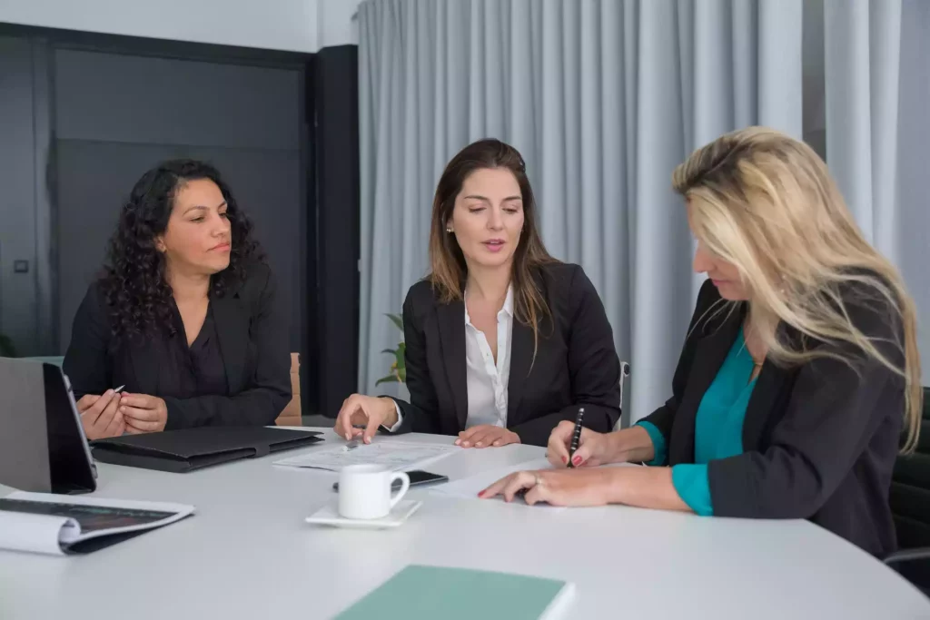 3 femmes en formations autour d'un bureau