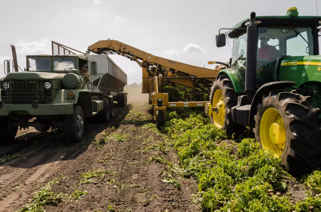 Photo de tracteurs dans les champs entrain de récolter leurs légumes, etc
