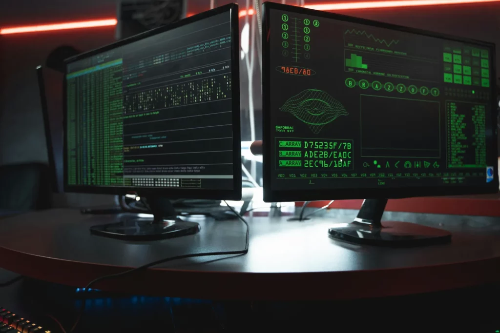Deux écrans d'ordinateur affichant des données codées, illustrant la cybersécurité.