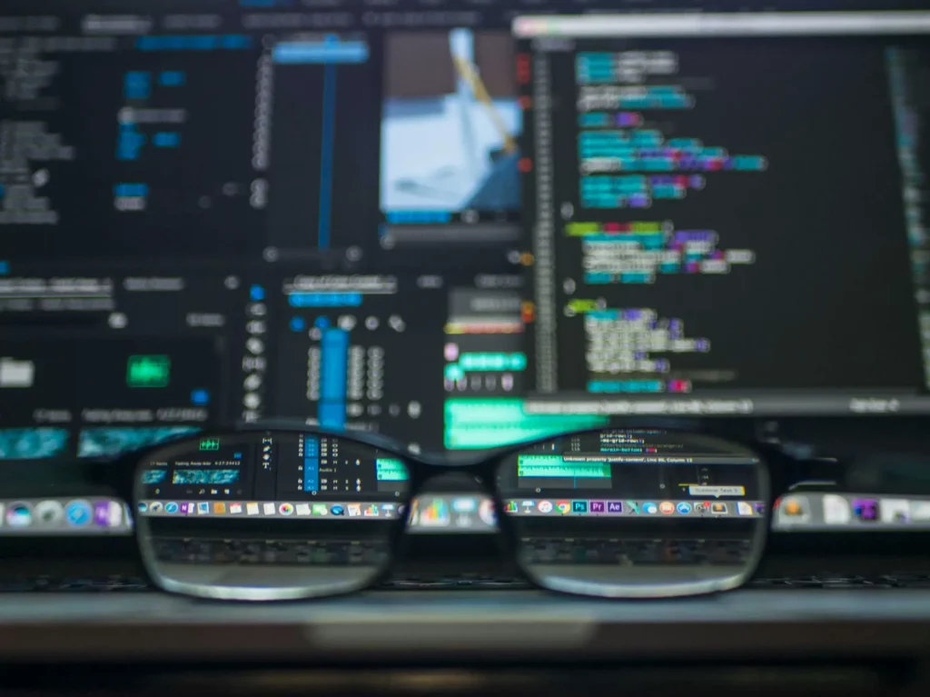on voit des lunettes avec un ordi en fond derrière